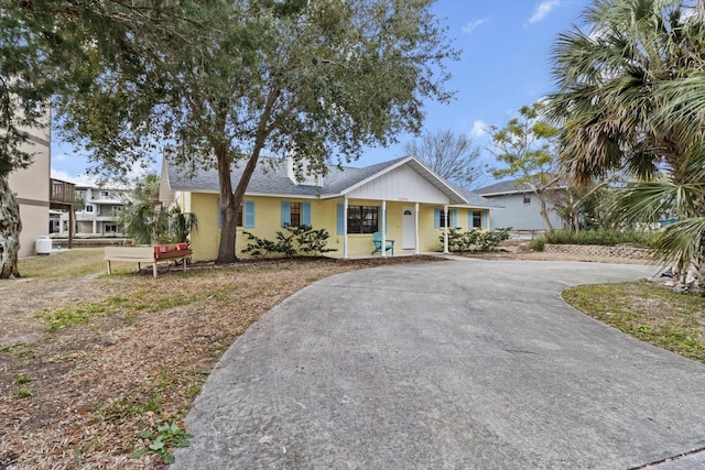 11770 W Sunnybrook Ct, Crystal River, FL 34429 - view of front of house with curved driveway, covered porch, and roof with shingles