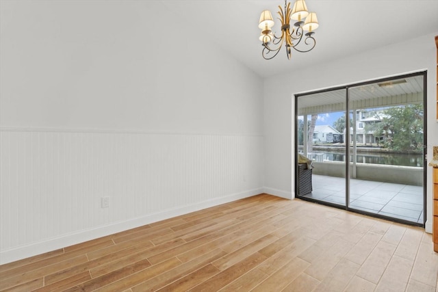 11770 W Sunnybrook Ct, Crystal River, FL 34429 - empty room with light wood finished floors, wainscoting, a chandelier, and a water view