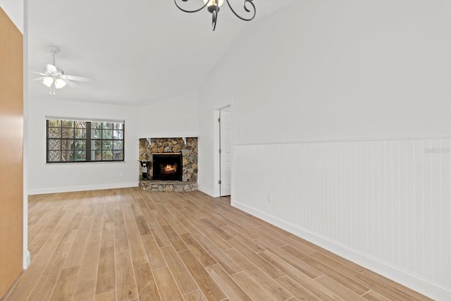 11770 W Sunnybrook Ct, Crystal River, FL 34429 - unfurnished living room featuring light wood-style floors, ceiling fan, vaulted ceiling, a chandelier, and a fireplace