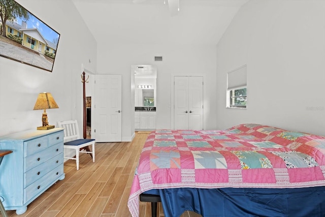 11770 W Sunnybrook Ct, Crystal River, FL 34429 - bedroom with light wood finished floors, high vaulted ceiling, a closet, and ensuite bath