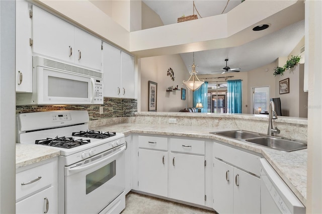 5512 Rosewall Cir, Leesburg, FL 34748 - kitchen with white appliances, tasteful backsplash, light countertops, white cabinets, and vaulted ceiling