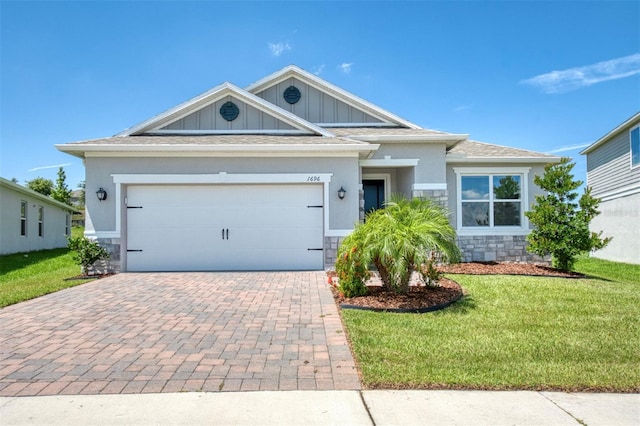 1696 Wilson Prairie Cir, Groveland, FL 34736 - view of front of house with stone siding, decorative driveway, a front yard, and board and batten siding