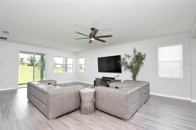 1696 Wilson Prairie Cir, Groveland, FL 34736 - living area featuring light wood-type flooring, ceiling fan, and a textured ceiling