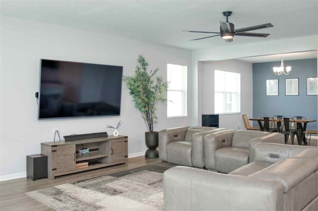 1696 Wilson Prairie Cir, Groveland, FL 34736 - living area with wood finished floors, a chandelier, and a ceiling fan