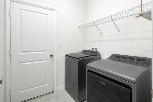 1696 Wilson Prairie Cir, Groveland, FL 34736 - laundry room with washing machine and dryer and light tile patterned flooring