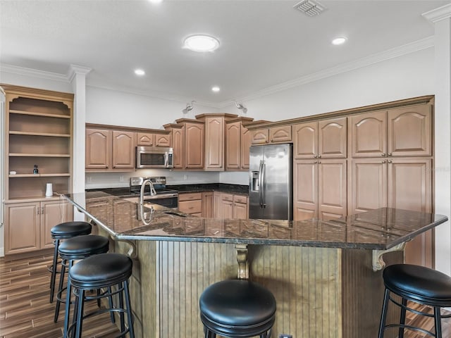 12198 SE 176th Loop, Summerfield, FL 34491 - kitchen featuring stainless steel appliances, a kitchen breakfast bar, dark wood-style floors, ornamental molding, and a spacious island