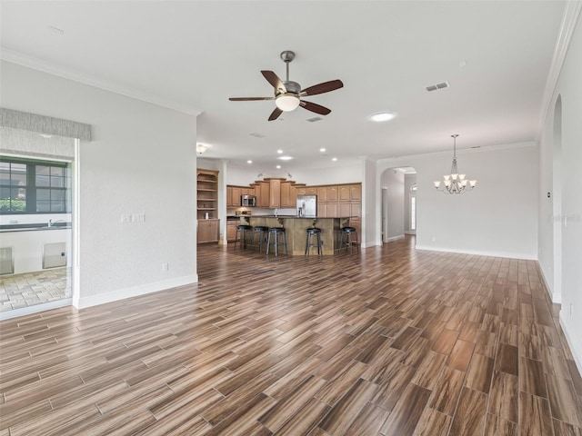 12198 SE 176th Loop, Summerfield, FL 34491 - unfurnished living room featuring arched walkways, wood finished floors, a ceiling fan, ornamental molding, and a chandelier