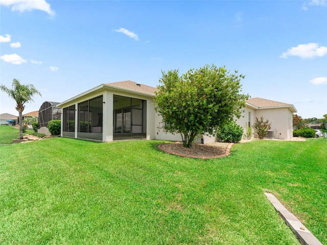 12198 SE 176th Loop, Summerfield, FL 34491 - back of house with a yard, a sunroom, and stucco siding