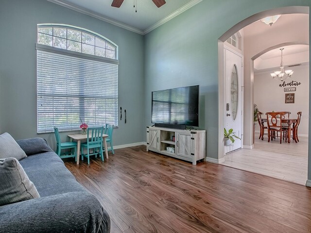 359 Blue Branch St, Eustis, FL 32736 - living room with arched walkways, crown molding, a chandelier, ceiling fan, and healthy amount of natural light