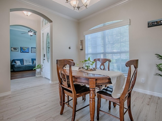 359 Blue Branch St, Eustis, FL 32736 - dining room with arched walkways, light wood-type flooring, crown molding, a chandelier, and a ceiling fan