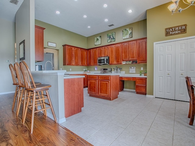 359 Blue Branch St, Eustis, FL 32736 - kitchen with stainless steel appliances, light countertops, a peninsula, a kitchen breakfast bar, and a chandelier