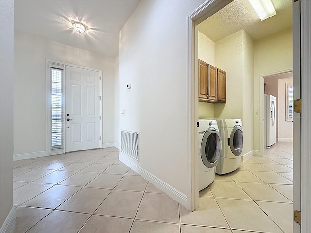 101 Flame Vine Way, Groveland, FL 34736 - laundry area with light tile patterned flooring, washing machine and clothes dryer, and cabinet space