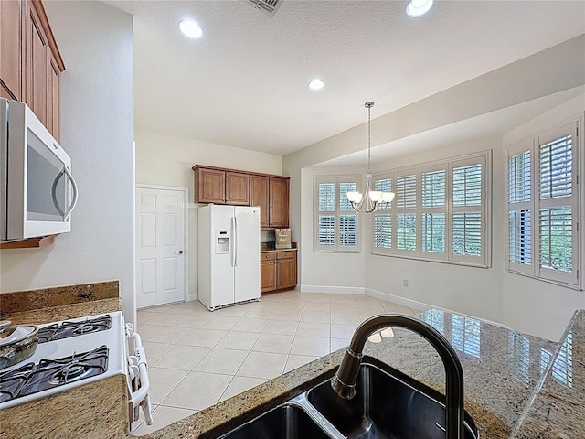 101 Flame Vine Way, Groveland, FL 34736 - kitchen featuring white appliances, a chandelier, brown cabinets, healthy amount of natural light, and recessed lighting