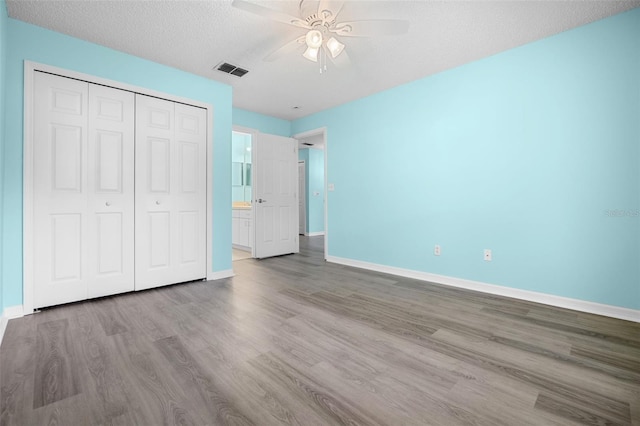 3586 Eversholt St, Clermont, FL 34711 - unfurnished bedroom with wood finished floors, a closet, a textured ceiling, and a ceiling fan