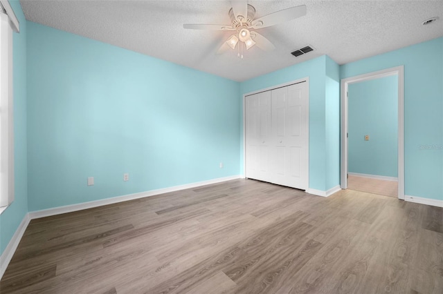 3586 Eversholt St, Clermont, FL 34711 - unfurnished bedroom featuring a textured ceiling, wood finished floors, a closet, and a ceiling fan