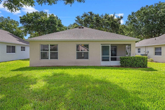 3586 Eversholt St, Clermont, FL 34711 - back of property with stucco siding, a shingled roof, and a lawn