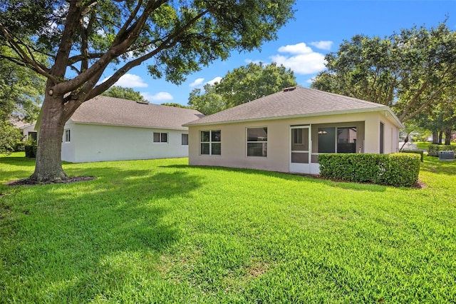 3586 Eversholt St, Clermont, FL 34711 - back of property with stucco siding, a lawn, and a shingled roof