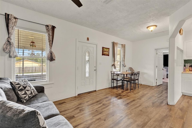 520 Dora Ave, Tavares, FL 32778 - living area featuring plenty of natural light, light wood-style floors, a textured ceiling, and a ceiling fan