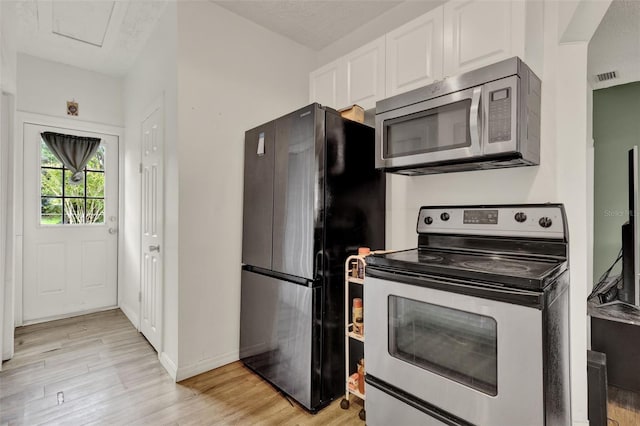 520 Dora Ave, Tavares, FL 32778 - kitchen with appliances with stainless steel finishes, white cabinetry, and light wood-style floors