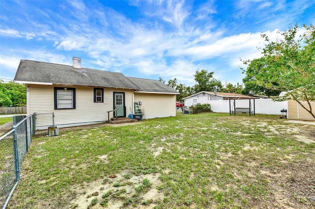 520 Dora Ave, Tavares, FL 32778 - back of property with entry steps, a fenced backyard, a chimney, and a storage shed