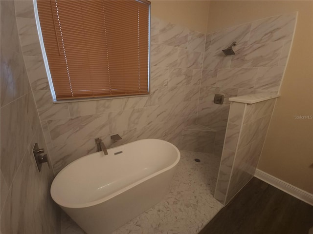 222 Bacopa Pass, Davenport, FL 33897 - bathroom with walk in shower, a soaking tub, and tile walls