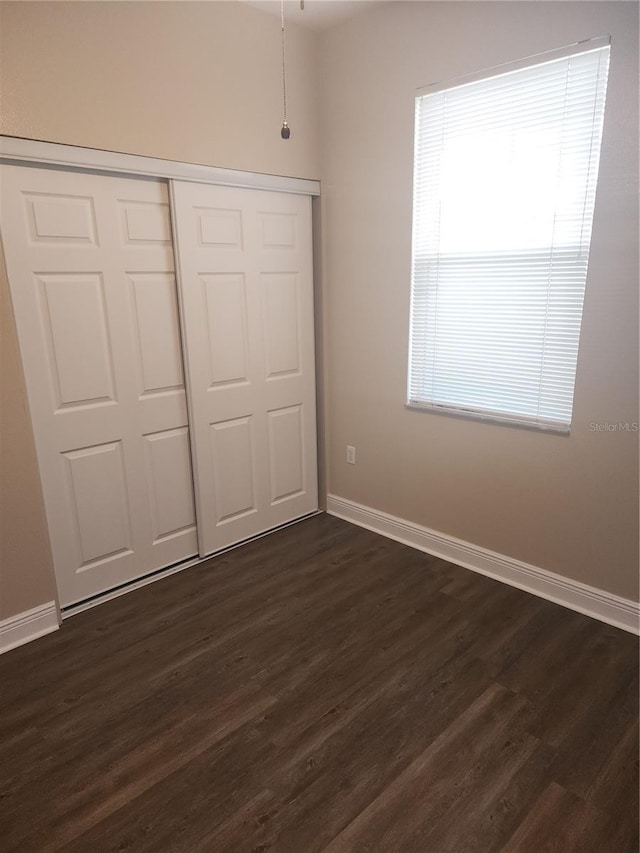 222 Bacopa Pass, Davenport, FL 33897 - unfurnished bedroom featuring dark wood finished floors and a closet