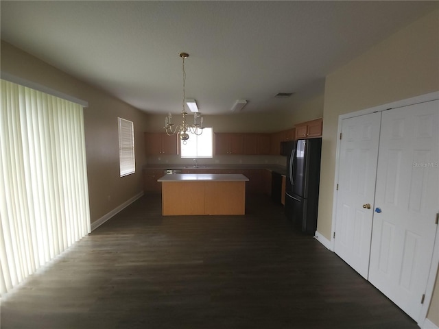 222 Bacopa Pass, Davenport, FL 33897 - kitchen with freestanding refrigerator, a kitchen island, a chandelier, dark wood finished floors, and pendant lighting