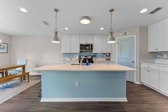 562 Meadow Ridge Dr, Saint Augustine, FL 32092 - kitchen featuring stainless steel appliances, tasteful backsplash, light countertops, dark wood-type flooring, and recessed lighting