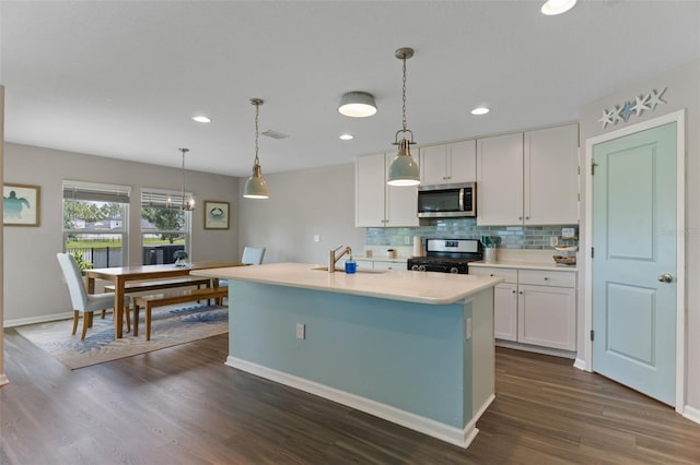 562 Meadow Ridge Dr, Saint Augustine, FL 32092 - kitchen with stainless steel appliances, white cabinetry, light countertops, backsplash, and dark wood-type flooring