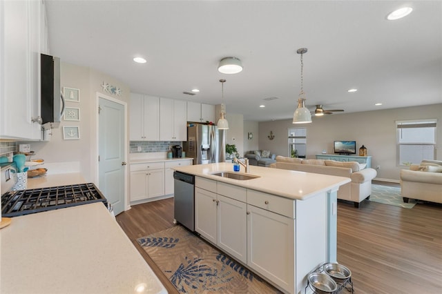 562 Meadow Ridge Dr, Saint Augustine, FL 32092 - kitchen featuring stainless steel appliances, open floor plan, light countertops, dark wood-style flooring, and decorative backsplash