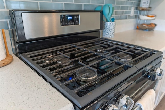 562 Meadow Ridge Dr, Saint Augustine, FL 32092 - kitchen view of stainless steel gas stove, light stone counters, and tasteful backsplash