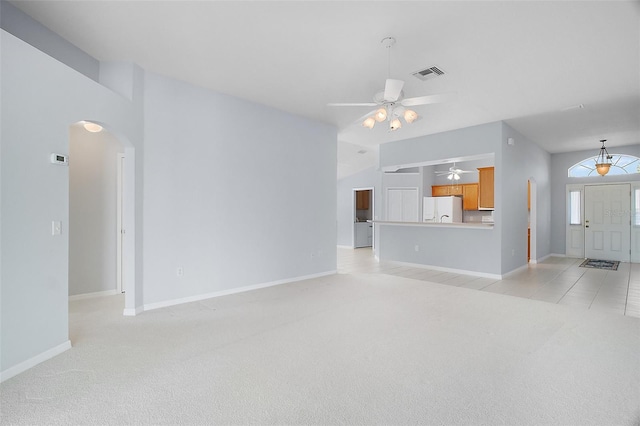 33234 Kaylee Way, Leesburg, FL 34788 - unfurnished living room featuring light colored carpet, arched walkways, ceiling fan, and vaulted ceiling