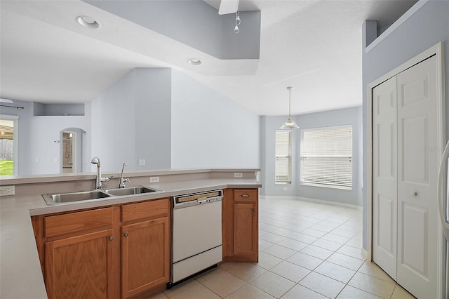 33234 Kaylee Way, Leesburg, FL 34788 - kitchen featuring white dishwasher, arched walkways, light tile patterned floors, light countertops, and decorative light fixtures
