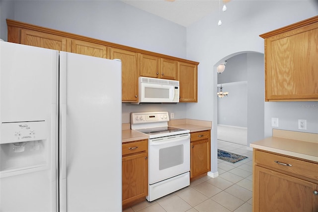 33234 Kaylee Way, Leesburg, FL 34788 - kitchen with white appliances, light tile patterned flooring, arched walkways, light countertops, and a chandelier