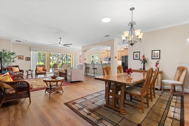 4210 Arlington Ridge Blvd, Leesburg, FL 34748 - dining space with light wood finished floors, ornamental molding, arched walkways, a chandelier, and a ceiling fan