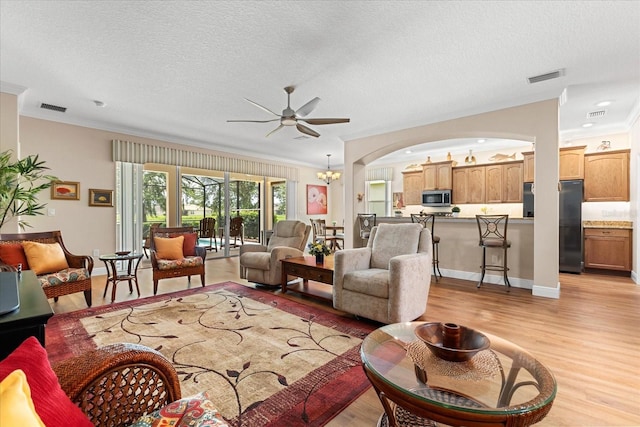 4210 Arlington Ridge Blvd, Leesburg, FL 34748 - living area featuring light wood finished floors, ceiling fan, crown molding, a textured ceiling, and arched walkways
