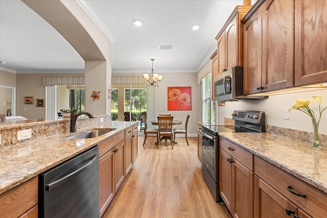 4210 Arlington Ridge Blvd, Leesburg, FL 34748 - kitchen featuring appliances with stainless steel finishes, light wood-style flooring, light stone counters, ornamental molding, and decorative light fixtures