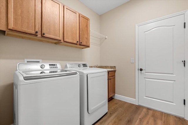 4210 Arlington Ridge Blvd, Leesburg, FL 34748 - washroom featuring washer and clothes dryer, light wood finished floors, and cabinet space