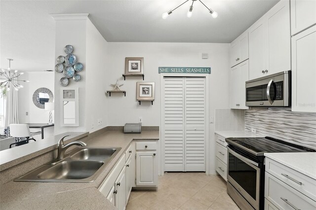 2639 Maitland Crossing Way Unit 102, Orlando, FL 32810 - kitchen featuring appliances with stainless steel finishes, a chandelier, white cabinetry, and light tile patterned floors