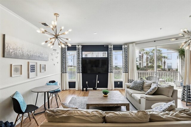 2639 Maitland Crossing Way Unit 102, Orlando, FL 32810 - living room featuring a chandelier, plenty of natural light, and light wood finished floors