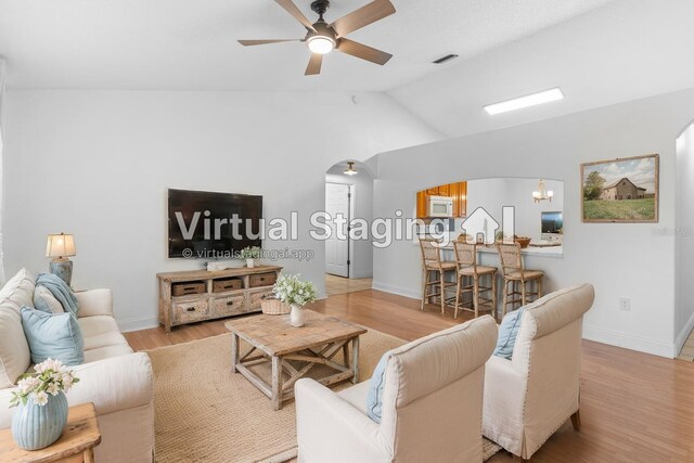 204 Lori Ct, Umatilla, FL 32784 - living room featuring arched walkways, ceiling fan, vaulted ceiling, and wood finished floors