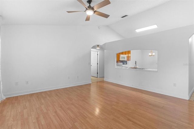 204 Lori Ct, Umatilla, FL 32784 - unfurnished living room featuring arched walkways, ceiling fan, light wood-style flooring, and vaulted ceiling