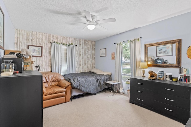 204 Lori Ct, Umatilla, FL 32784 - bedroom featuring wallpapered walls, an accent wall, light carpet, a textured ceiling, and a ceiling fan