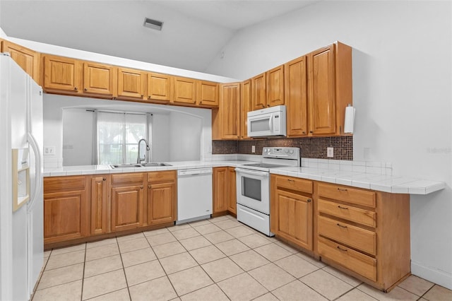 204 Lori Ct, Umatilla, FL 32784 - kitchen featuring white appliances, lofted ceiling, decorative backsplash, light tile patterned floors, and a peninsula