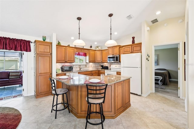 3460 Idlewood Loop, The Villages, FL 32162 - kitchen with white appliances, light stone counters, recessed lighting, a center island, and tasteful backsplash