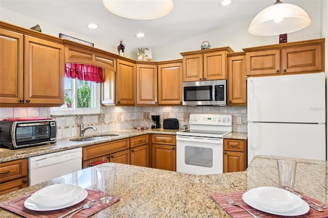 3460 Idlewood Loop, The Villages, FL 32162 - kitchen with white appliances, brown cabinets, backsplash, and recessed lighting