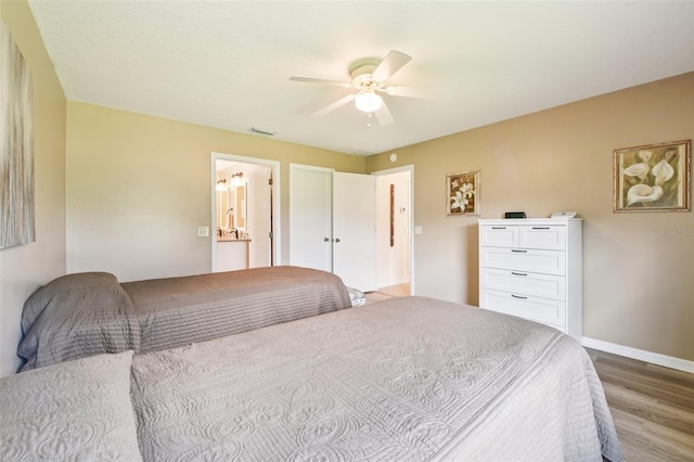 3460 Idlewood Loop, The Villages, FL 32162 - bedroom with wood finished floors, ceiling fan, and ensuite bathroom