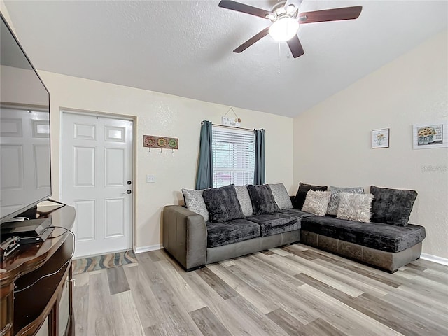 12181 SE 87th Ct, Belleview, FL 34420 - living room featuring ceiling fan, light wood finished floors, vaulted ceiling, and a textured ceiling