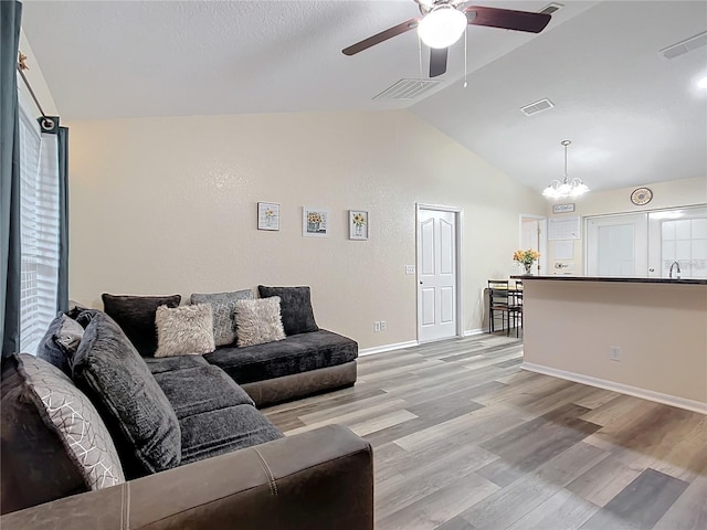 12181 SE 87th Ct, Belleview, FL 34420 - living area with lofted ceiling, ceiling fan, a chandelier, and light wood-style flooring