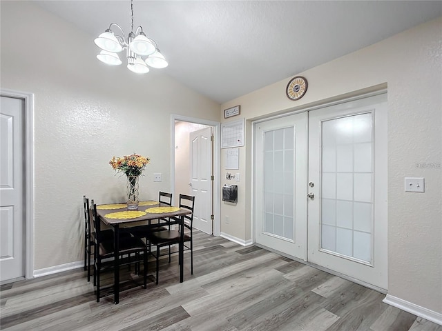 12181 SE 87th Ct, Belleview, FL 34420 - dining space featuring a chandelier, wood finished floors, french doors, vaulted ceiling, and a textured wall